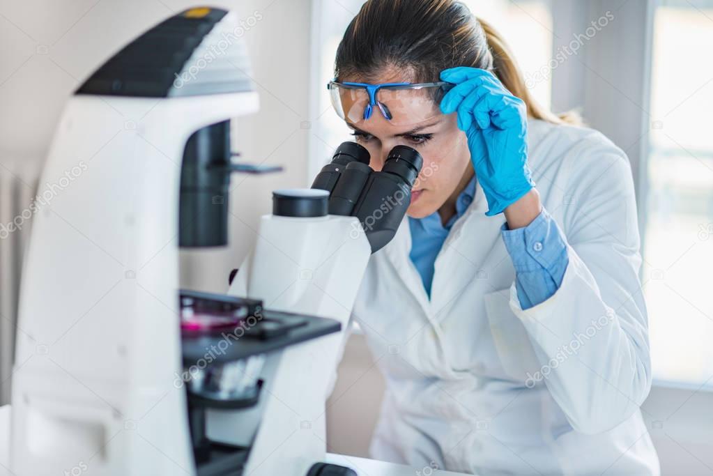 Female chemist or lab technician researching samples in laboratory