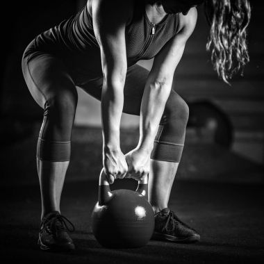 Kadın atlet kettlebell ile kapalı egzersiz