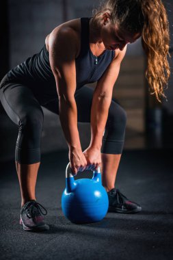 Kadın atlet kettlebell ile kapalı egzersiz