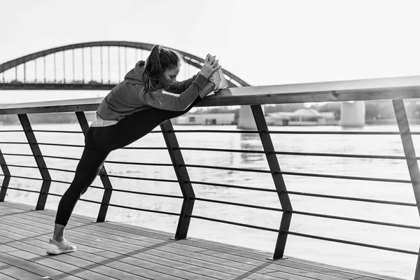 Streching Kobieta Nad Rzeką Mieście Zachodzie Słońca — Zdjęcie stockowe