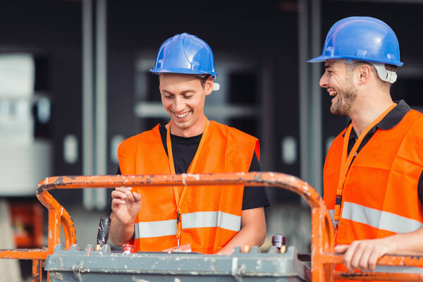 Construction workers operating on machine