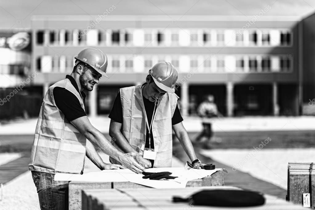 Construction Workers with Plans on Construction site