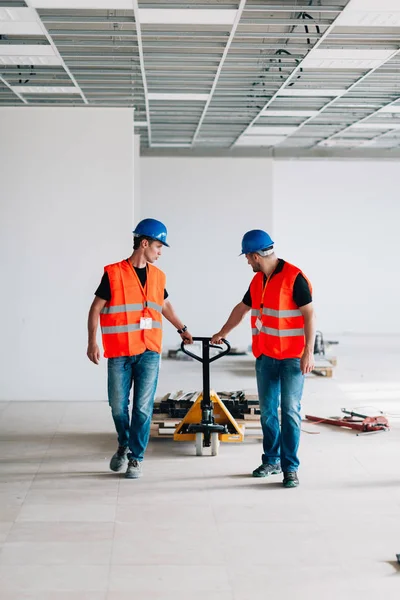 Lavoratori Manuali Che Guidano Materiale Costruzione Con Transpallet Manuale — Foto Stock