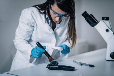 Adli tıp Lab. adli kanıtlar silahla inceleyerek bilim adamı