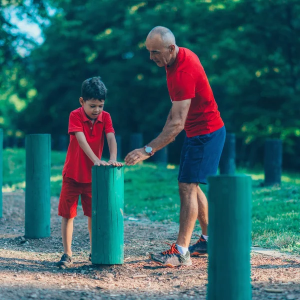 祖父和孙子在公园里跳过木制的蜷缩 — 图库照片