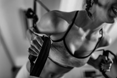 Genç kadın trx üzerinde spor salonunda egzersiz