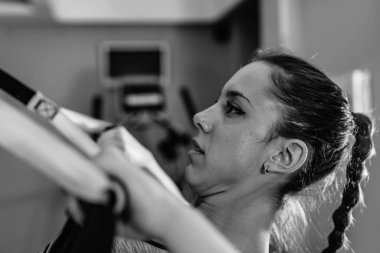 Genç kadın trx üzerinde spor salonunda egzersiz