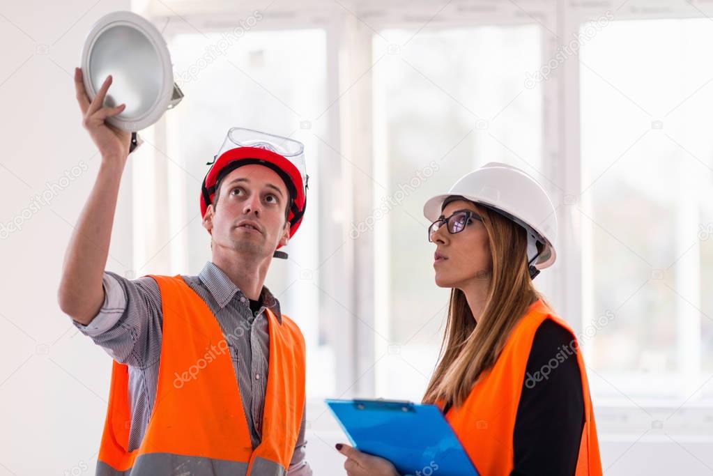 Maintenance Engineers on construction site checking light