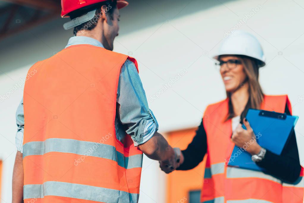 Business people handshaking on construction site