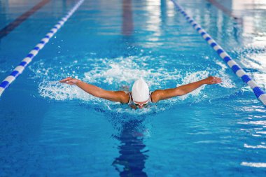 Kadın cankurtaran yüzme havuzunda eğitim. Kelebek stil Yüzme