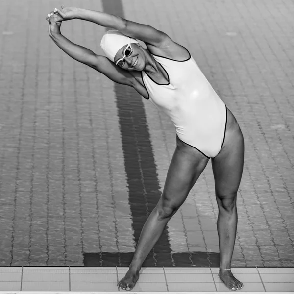 Female swimmer streching on poolside