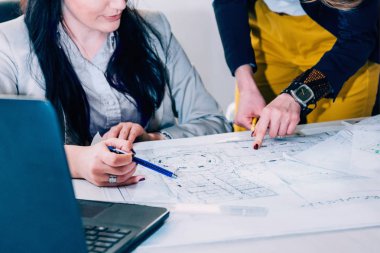 Ofis planı üzerinde çalışan mimarlar 