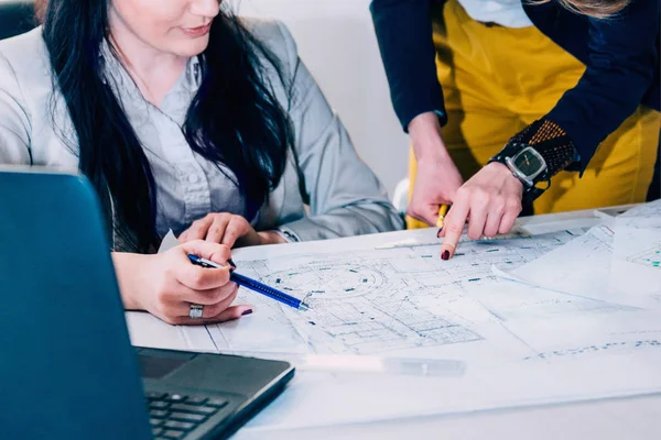 Ofis planı üzerinde çalışan mimarlar 