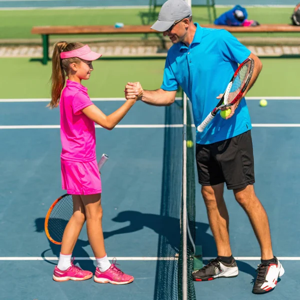 male trainer with girl at Tennis training