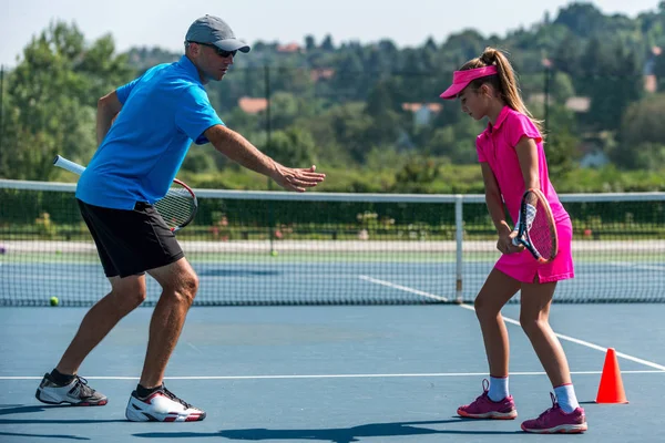 male trainer with girl at Tennis training