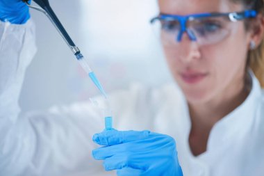 Genç kadın bilim araştırma laboratuarında pipet kullanarak