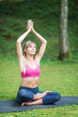 Güzel genç kadın yoga, yaparken eller dua bulunduğu