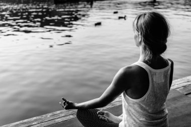 Lotus pratik yoga göl kenarında positing içinde kadın