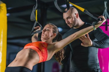  Kişisel antrenör ile jimnastik salonu kadın trx üzerinde egzersiz