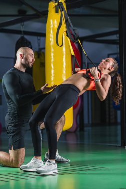  Kişisel antrenör ile jimnastik salonu kadın trx üzerinde egzersiz