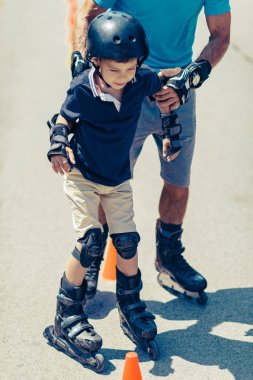 Küçük çocuk parkta sınıf pratik ile paten kıdemli öğretmeni