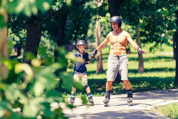 Liten Pojke Lärande Rullskridskoåkning Parken Med Sin Farfar — Stockfoto