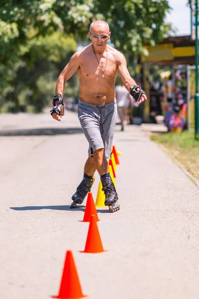 Senior man roller skating in park