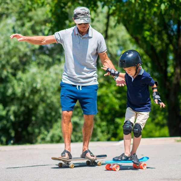 Senior Mit Kleinem Jungen Beim Skateboarden Park — Stockfoto