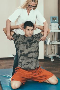 Physical therapist stretching patient's arms clipart
