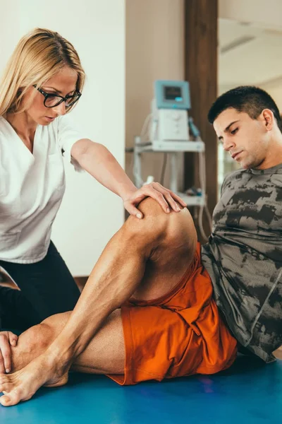 Φυσική Θεραπευτής Τεντώνοντας Πόδι Του Ασθενούς — Φωτογραφία Αρχείου