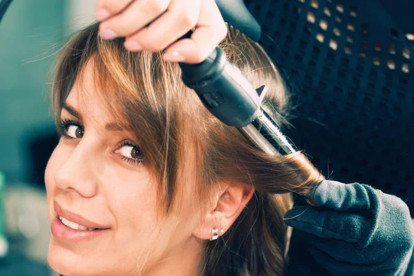 hairdresser Curling hair with curling iron