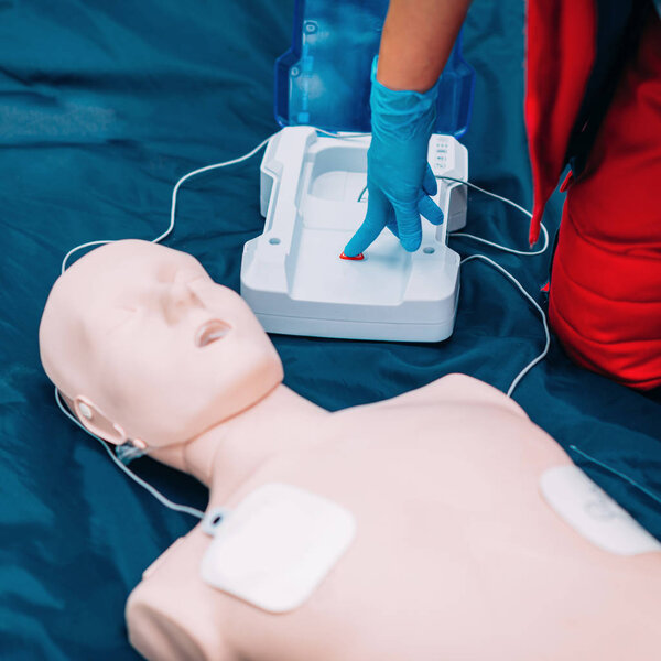 Cpr practice of woman on cpr dummy outdoors