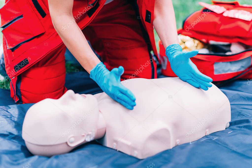 Cpr practice of woman on cpr dummy outdoors