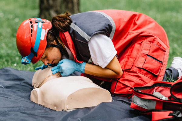 Cpr training of woman on cpr dummy outdoors