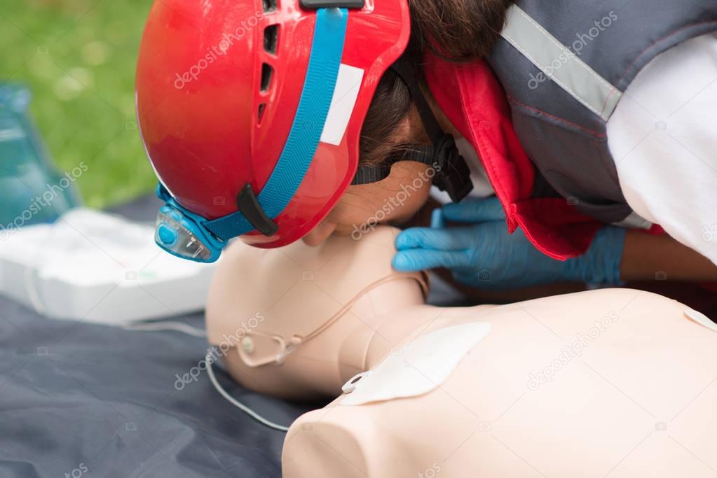 Cpr training of woman on cpr dummy outdoors