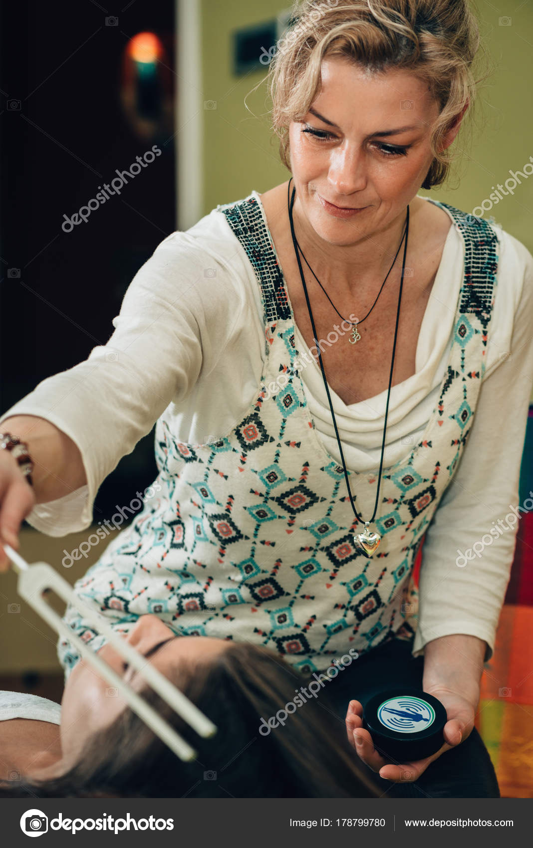 Woman Using Tuning Fork Sound Therapy — Stock Photo © microgen 178799780
