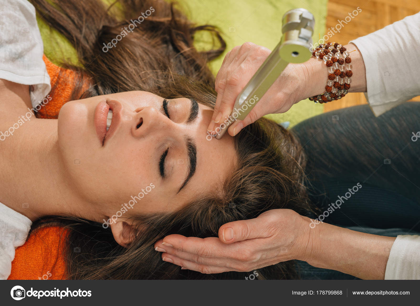 Woman Using Tuning Fork Sound Therapy — Stock Photo © microgen 178799868