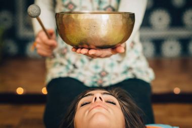 Tibet singing bowl ses terapisi kullanan kadın