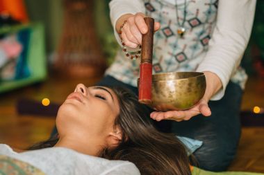 Tibet singing bowl ses terapisi kullanan kadın