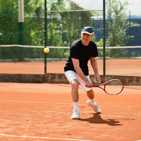 Hombre Mayor Golpeando Pelota Pista Tenis —  Fotos de Stock