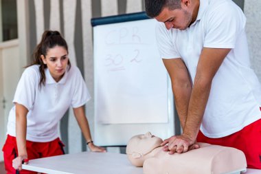 Kalp masajı sınıf konuşuyor ve ilk yardım, sıkıştırma oranı ve reanimasyon yordamı zekâ Cpr masaya kukla gösteren öğretim elemanları ile