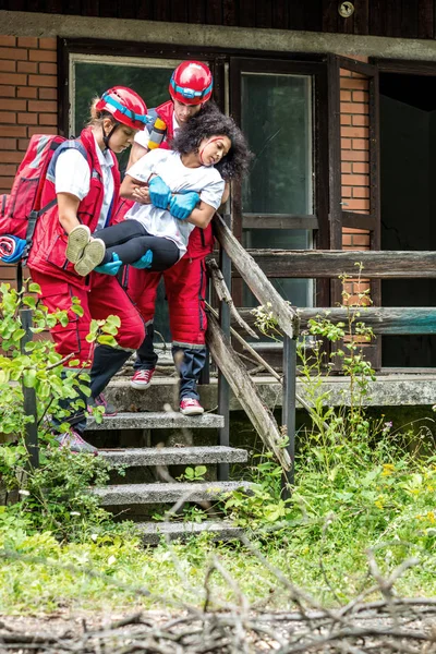 Equipo Rescate Evacuar Víctima Femenina Casa —  Fotos de Stock