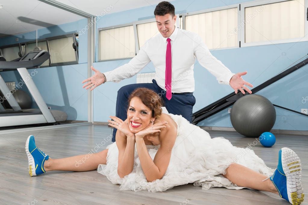 Bride stretching and groom standing under her