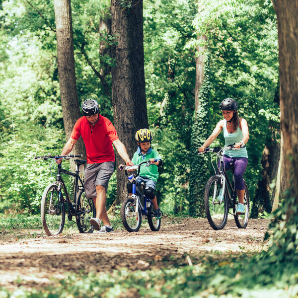 Cheerful family biking together in park