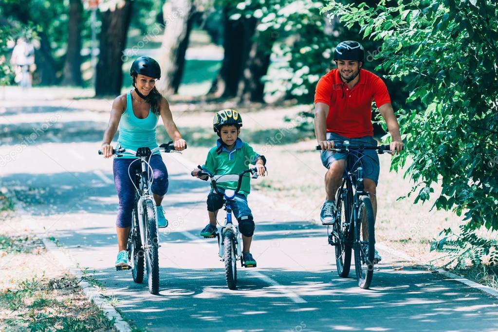 Cheerful family biking in park