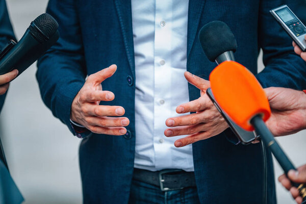 journalists interviewing businessman on press conference