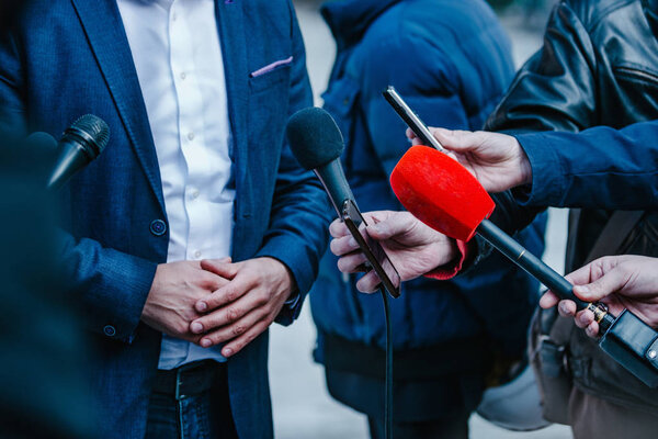 журналисты берут интервью у бизнесмена на пресс-конференции
