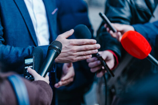 journalists interviewing businessman on press conference