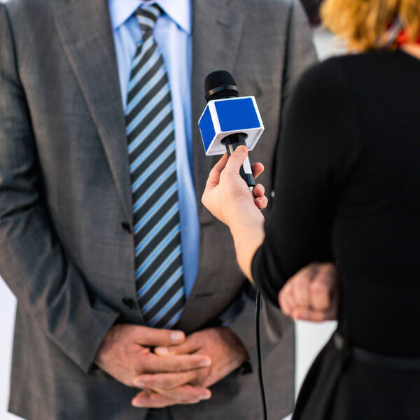 Journalist interviewing business person on public event  