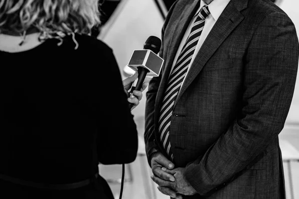 Journalist interviewing business person on public event